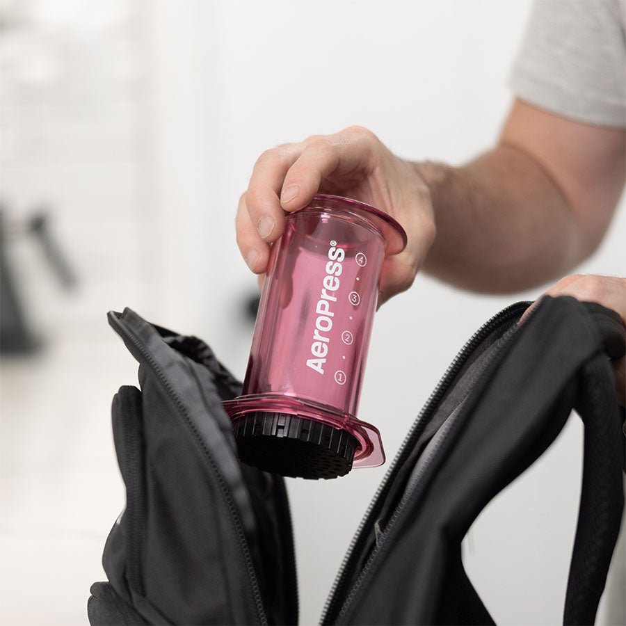 AeroPress Clear Pink wird in den Rucksack gepackt