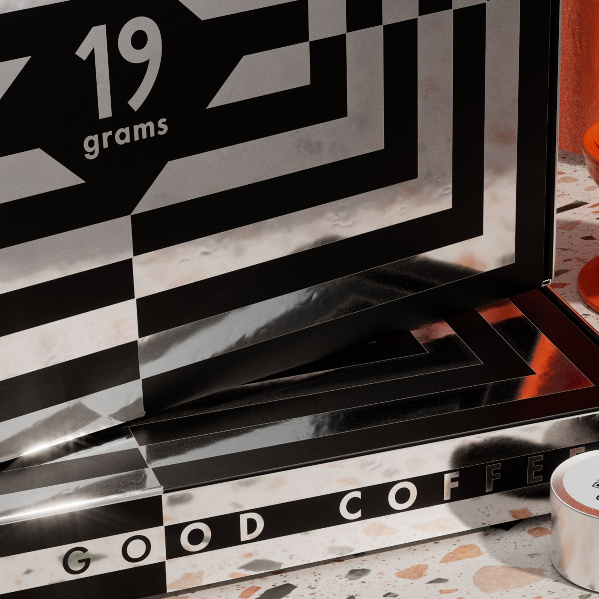 19grams Specialty Coffee Adventskalender 2026 – Detailaufnahme der Verpackung mit 19grams Logo und Schriftzug „Good Coffee“ im schwarz-weißen Muster auf Terrazzo-Oberfläche, Kaffeerösterei Berlin