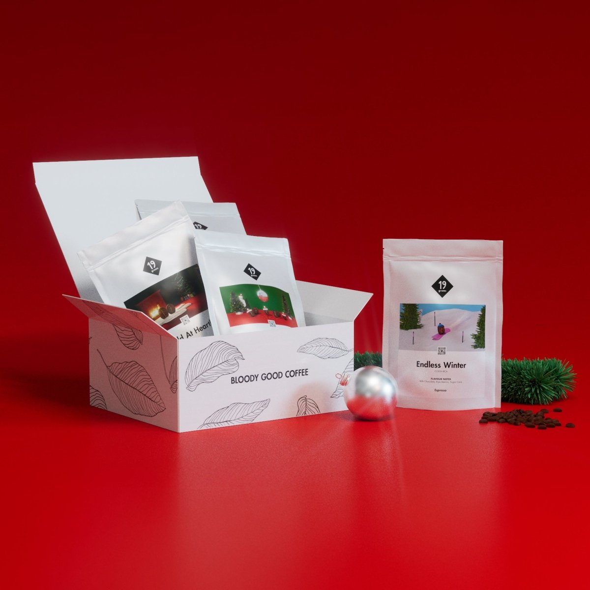 19grams Weihnachts-Geschenkset mit Filterkaffee-Sorten in weißer Box mit Kaffeeblatt-Design vor rotem Hintergrund