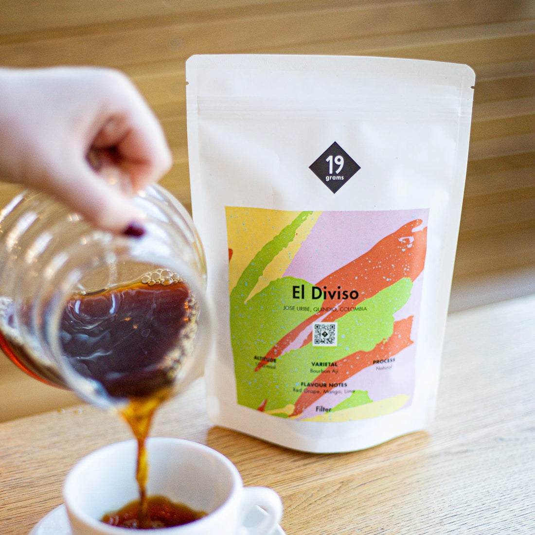 19grams El Diviso Rare Filter Kaffee aus Kulumbien auf dem Tisch präsentiert während eine Tasse mit Kaffee gefüllt wird.