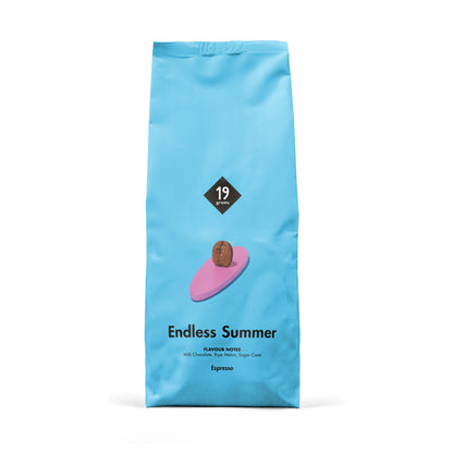 19grams Endless Summer Espresso – 1kg Packung – Produktfoto der Verpackung mit Illustration einer Kaffeebohne auf pinkem Surfbrett