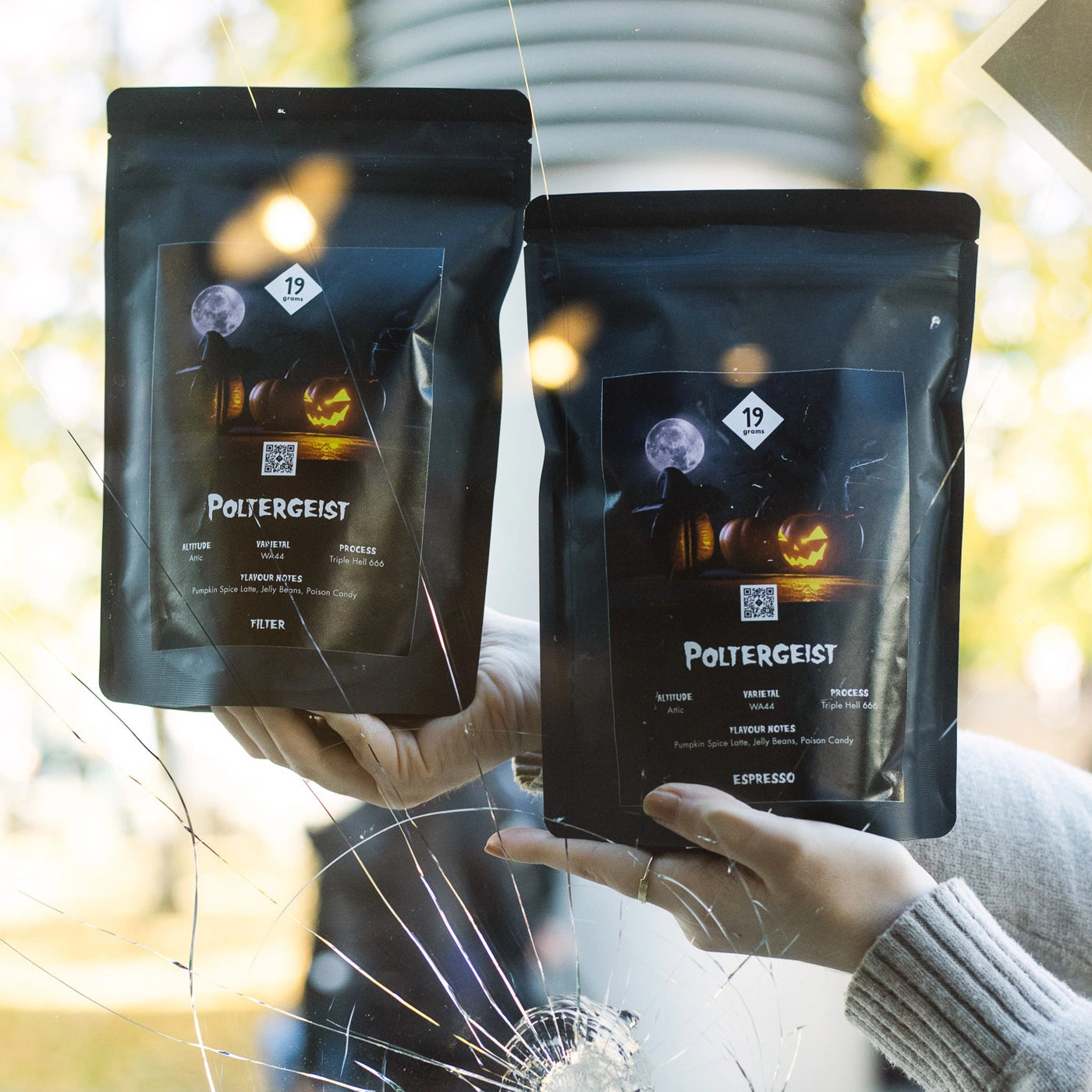 Zwei Tüten Halloween Kaffee Poltergeist von 19grams in der Hand präsentiert.