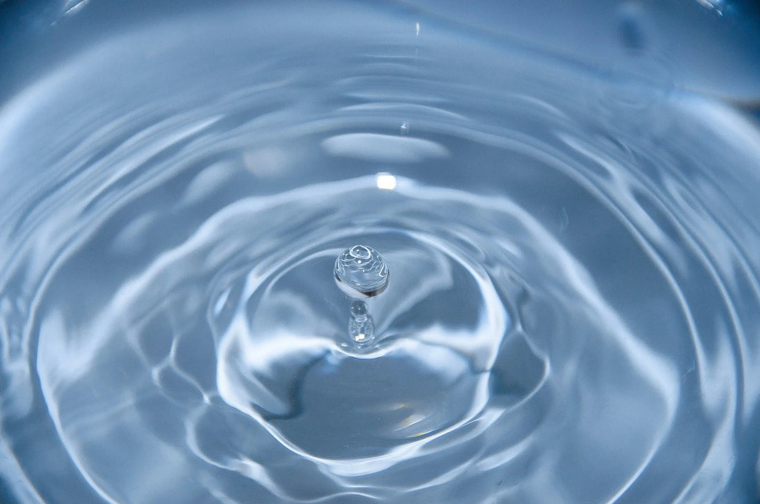 Ein Bild vom Wassertropfen, das auf die Oberfläche landet
