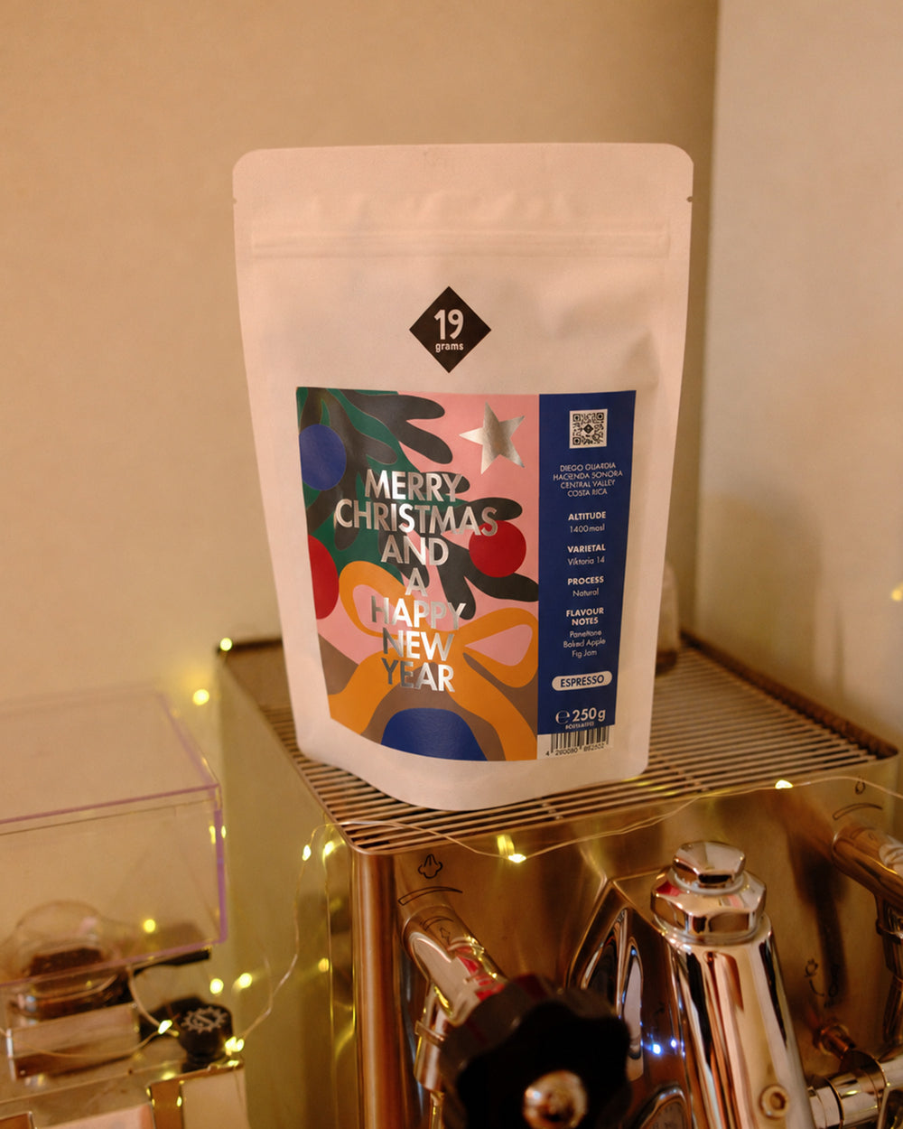 19grams Christmas Coffee Espresso Kaffee – 250g – blauer Espresso-Beutel auf einer Siebträgermaschine mit Lichterkette