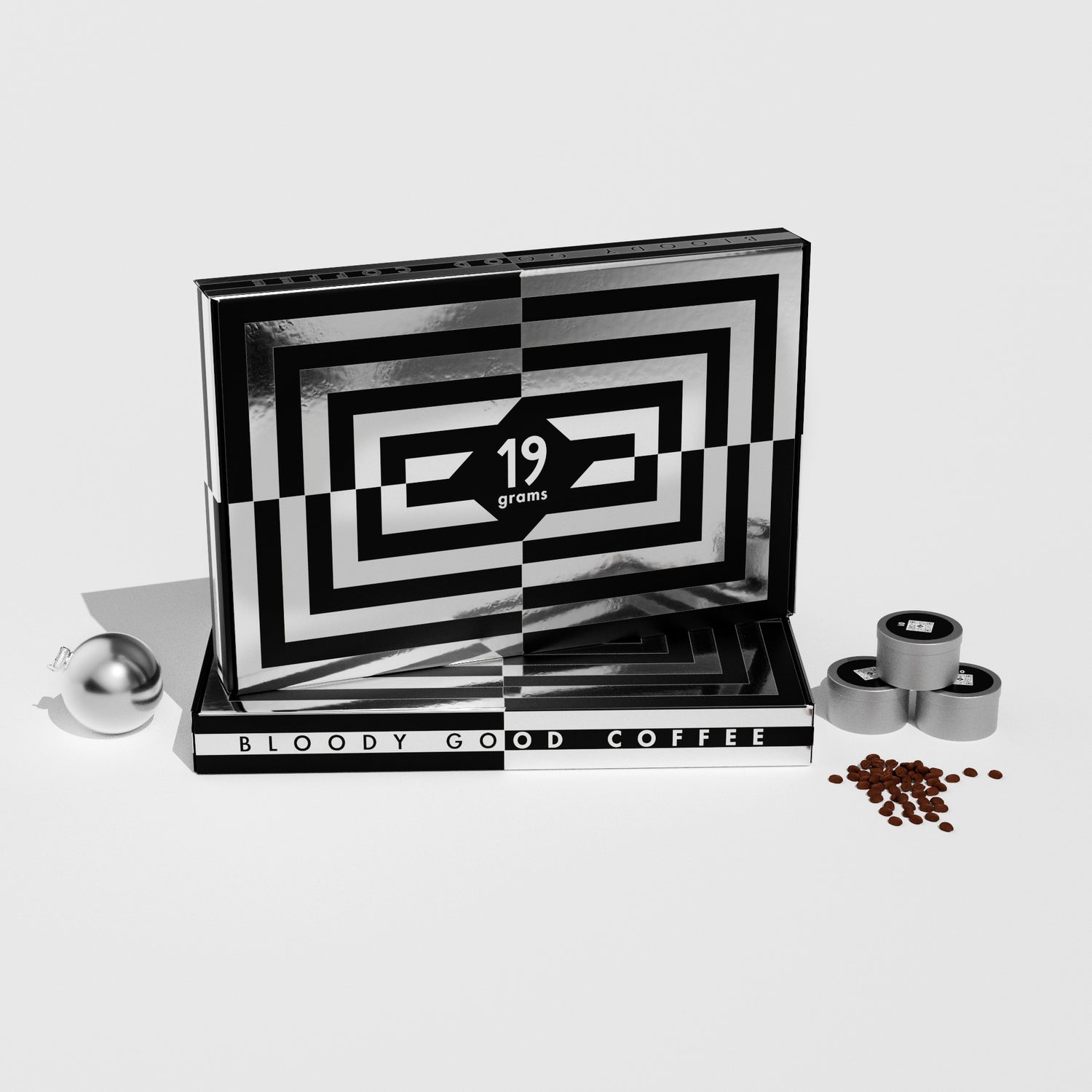 19grams Xmas in July Specialty Coffee Adventskalender – Geschenkbox mit schwarz-weißem Muster und Schriftzug „Bloody Good Coffee“, mit Kaffeedosen, silberner Weihnachtskugel und Kaffeebohnen auf weißem Hintergrund, Kaffeerösterei Berlin