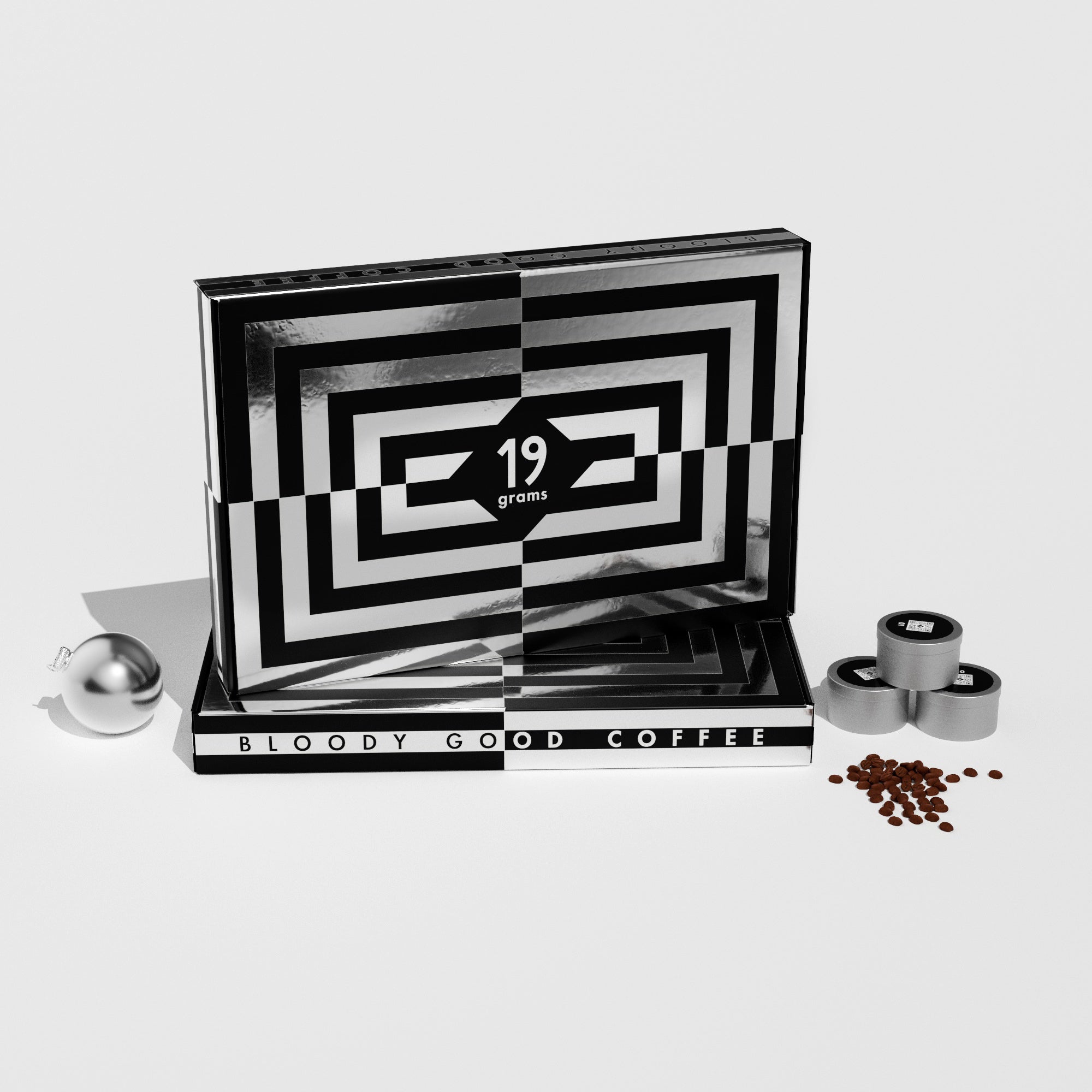19grams Xmas in July Specialty Coffee Adventskalender – Geschenkbox mit schwarz-weißem Muster und Schriftzug „Bloody Good Coffee“, mit Kaffeedosen, silberner Weihnachtskugel und Kaffeebohnen auf weißem Hintergrund, Kaffeerösterei Berlin